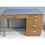 A 1950s single pedestal desk the top inset with gilt tooled blue writing surface fitted with one