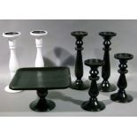 An ebonised wooden tazza, two pairs of ebonised turned wooden candlesticks and a pair of white