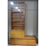 A teak base unit and two sets of glazed book shelves, a further glazed bookshelf and another unit