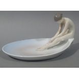 A Bing and Grondahl porcelain dish modelled with a naked female seated on the fig shaped bowl,