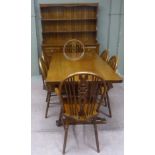 A Cryercraft dining suite comprising dresser, table and set of six wheel back dining chairs, brass