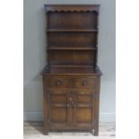 A Reproduction oak dresser the shelved back above two short drawers and pair of panelled