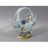 A continental porcelain basket the pastel blue body floral encrusted with infant figure to the