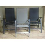 Two folding black fabric garden chairs together with another larger silver folding garden chair with