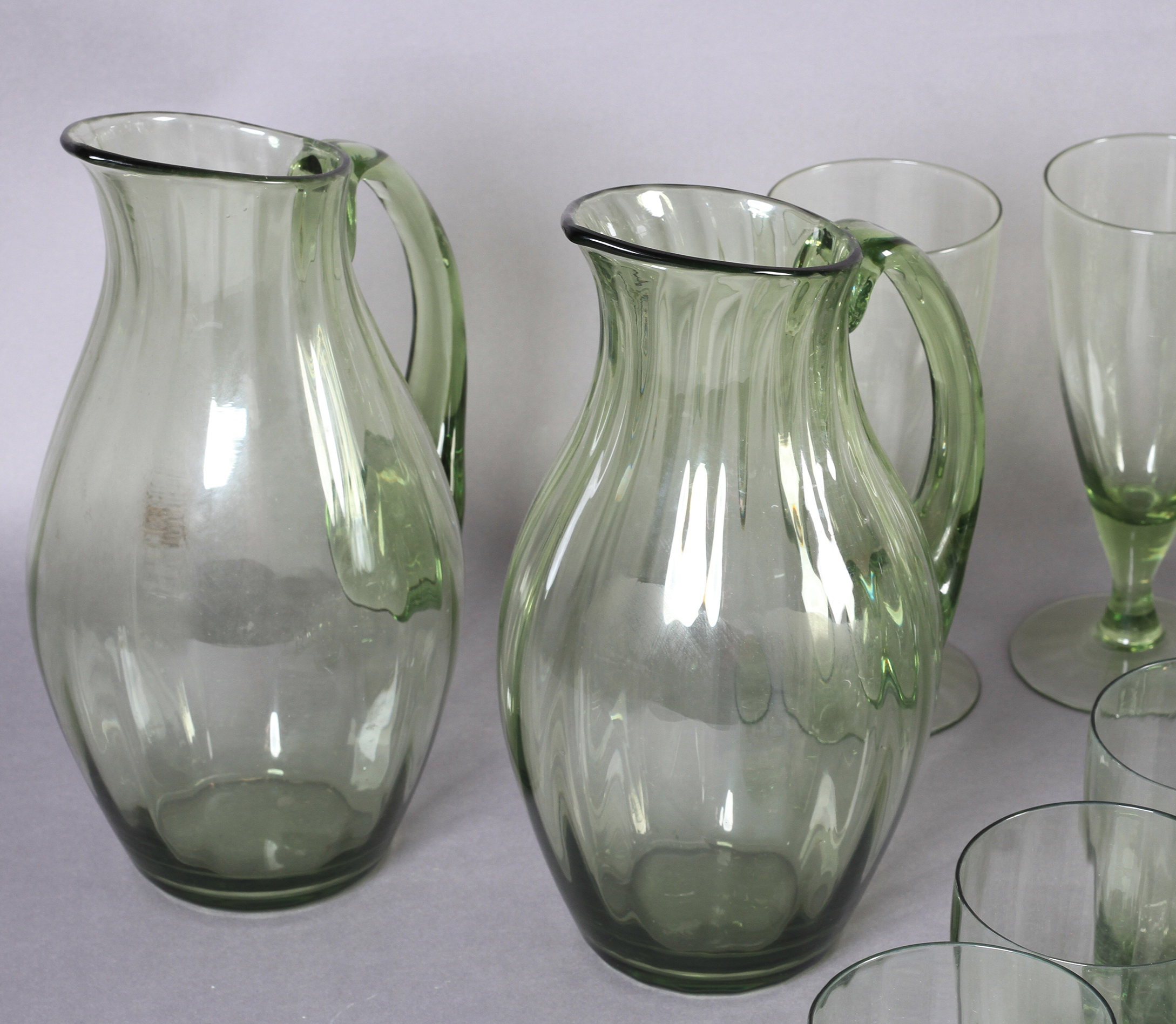 A SUITE OF WHITEFRIARS GREEN GLASS TABLE WARE, designed by William