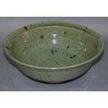 A Studio Pottery circular bowl with ash glaze, 27cm diameter x 10cm high (af)