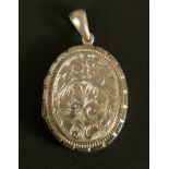 A Victorian oval silver locket by Adie and Lovekin Birmingham 1884, fully foliate scroll engraved