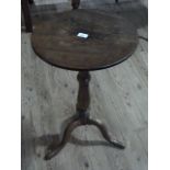 An oak and mahogany tripod table having a circular top on a turned column and cabriole base