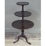 A reproduction mahogany dumb waiter on tripod base