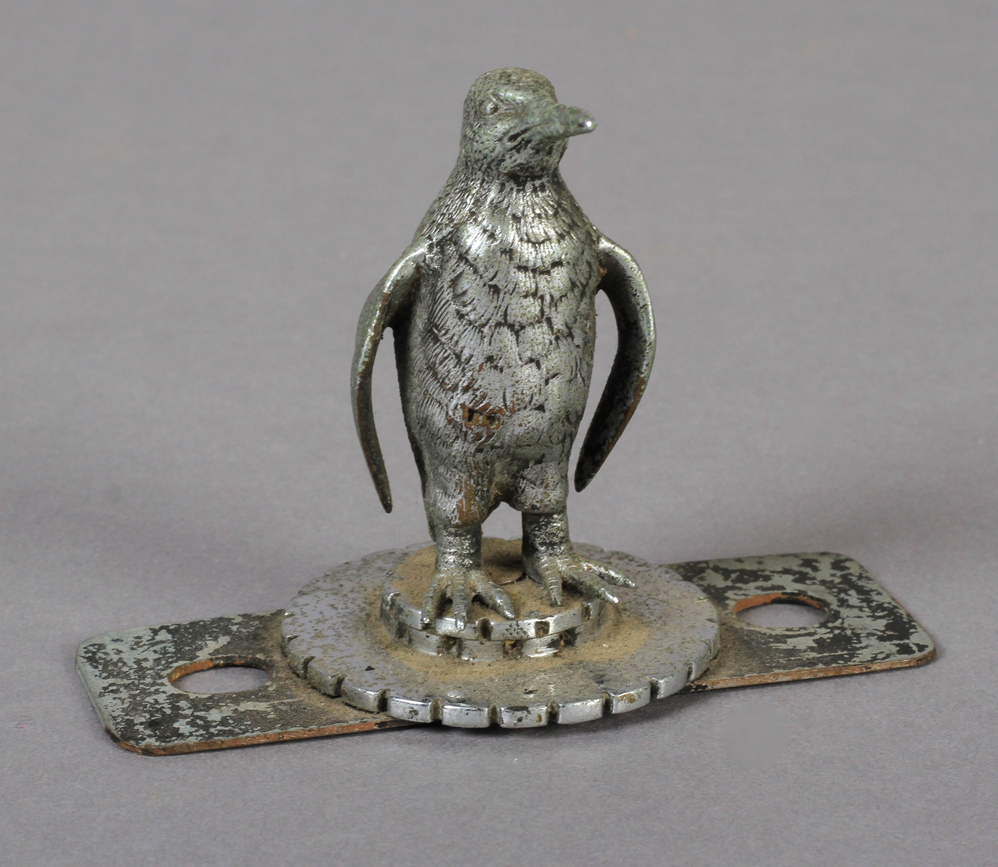 A Penguin car mascot, chrome, on circular notched base, 7cm high, c.1920/1930