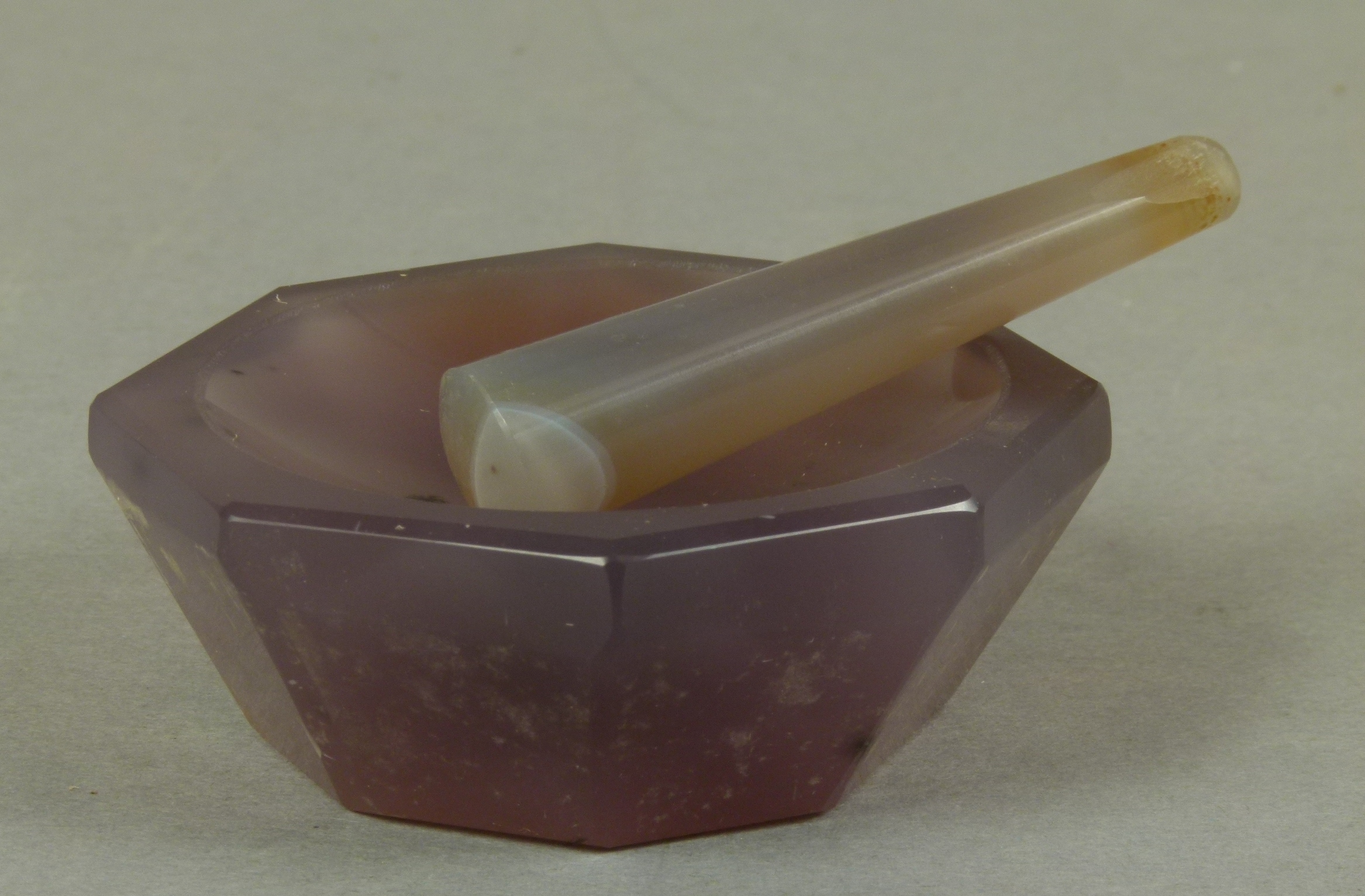 A mortar and pestle, the hexagonal mortar carved in amethyst, approximate diameter 7cm, the pestle a