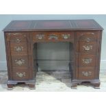 A mahogany kneehole desk with leather incised top, having a drawer to the centre flanked by four