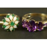 An amethyst dress ring, three graduated oval faceted stones claw set in line flanked by channel