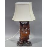 A Chinese hardwood figural lamp the pot bellied figure with arms aloft, hardwood base, together with