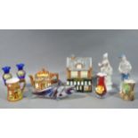 A biscuit barrel in the form of a shop, a marble glass fish, a cottage teapot and mug, Fauna vase,