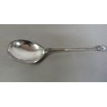 A Continental silver coloured metal spoon with cast shell terminal, reeded tine and fig shaped bowl,