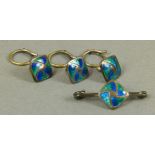 An Art Nouveau tie pin and collar stud set in silver, set with blue and green basse taille enamel,