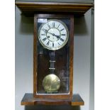 A Vienna style walnut wall clock with architectural pediment above a glazed door enclosing a cream