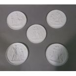 A set of five Parian ware circular plaques each depicting classical scenes in relief, 14cm diameter