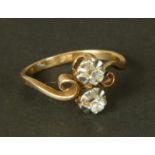 A two stone diamond ring in 14ct yellow and white gold, c.1950, the old European cut stones claw set