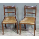 A pair of Regency mahogany dining chairs having a bar back and turned tie rail, later upholstered