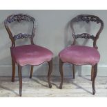 A pair of Victorian mahogany balloon back salon chairs carved with fruiting vine, upholstered