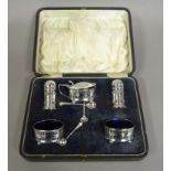 A George VI silver cruet comprising pair of pepperettes, pair of salts and lidded mustard with