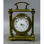 A brass cased mantel clock with fixed carrying handle, the circular drum case contained within