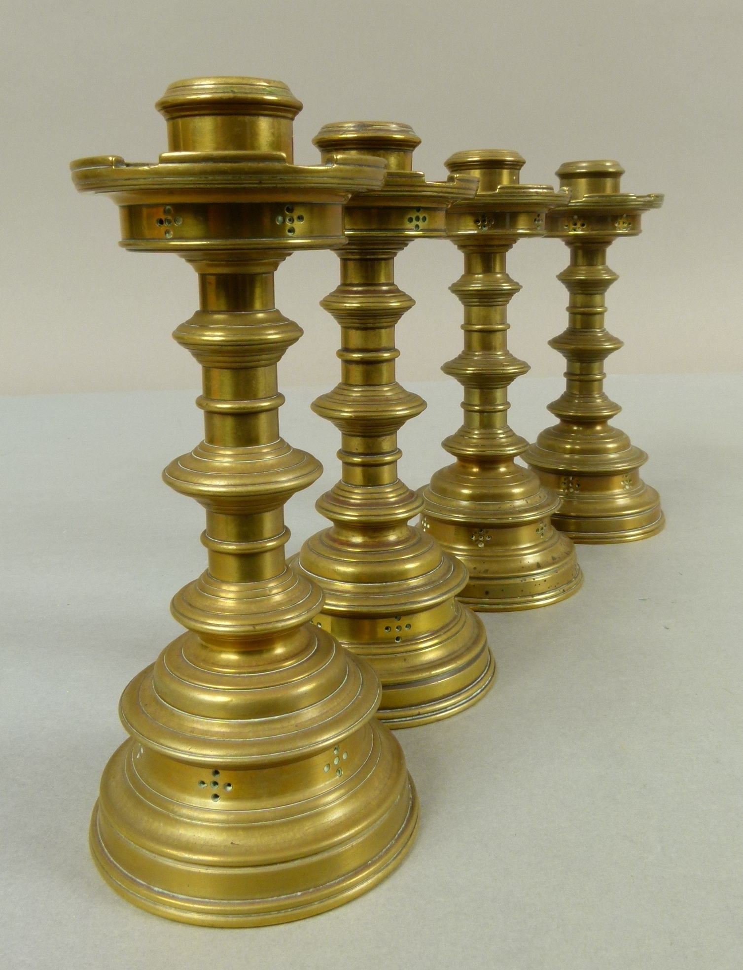 A set of four Victorian brass table candlesticks in the 'Gothic' style, cylindrical nozzles with - Image 2 of 3