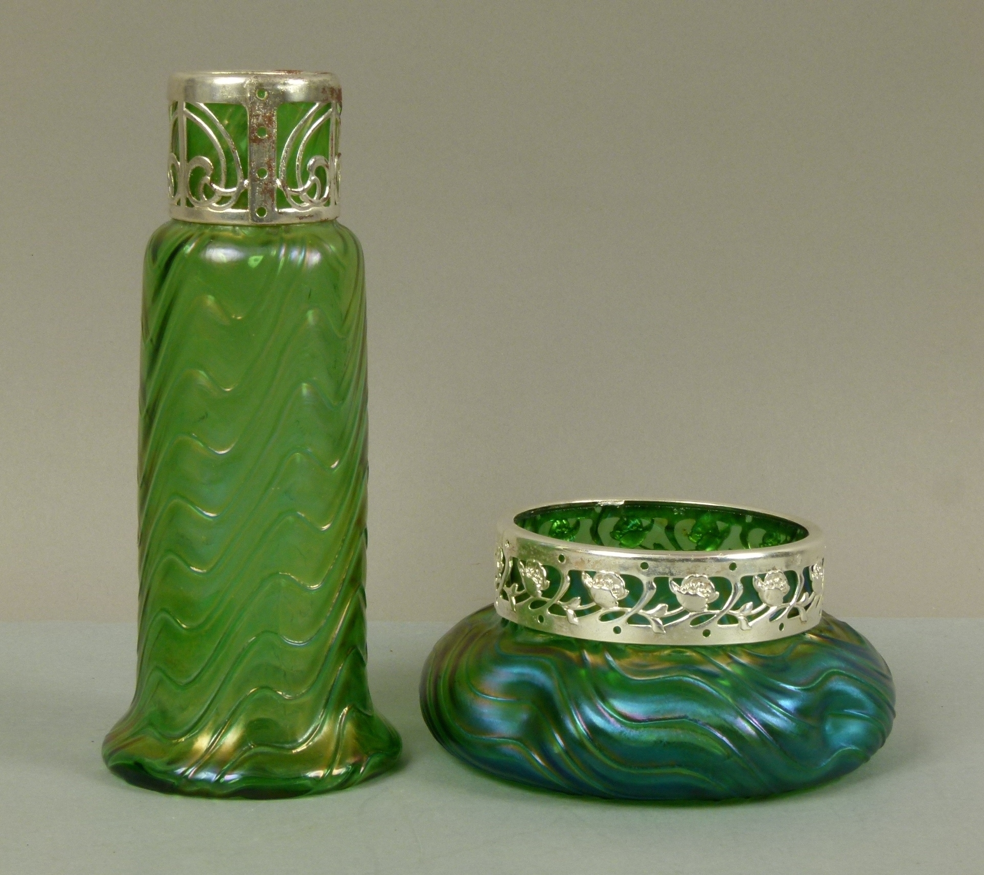 A Loetz style iridescent green glass vase of tapered cylindrical form with spreading foot, moulded