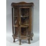 A reproduction mahogany stained beech bow front miniature display cabinet with serpentine-shaped