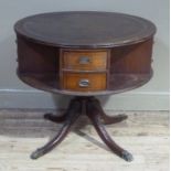 A reproduction mahogany finish drum table with leather incised surface and four sets of two