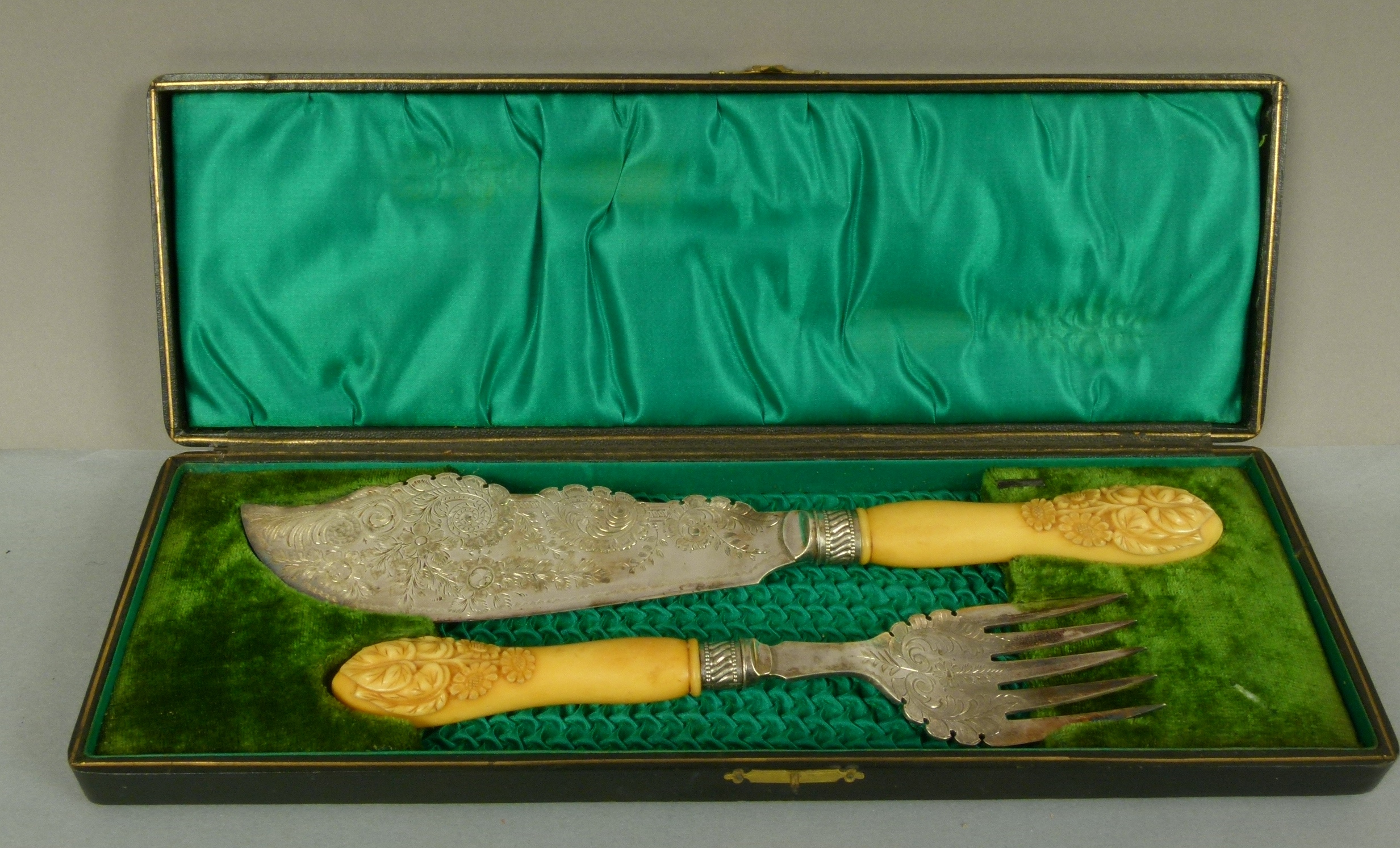 A pair of Victorian silver plated fish servers, with foliate engraved handles, the ivory handles