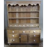 A Victorian style pine dresser and rack having a moulded cornice and ogee shaped frieze, planked