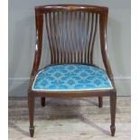 An Edwardian mahogany rail back nursing chair having a satinwood florette paterae to the top rail,