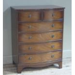 A reproduction mahogany finish bow front chest of two short and four long drawers on bracket feet