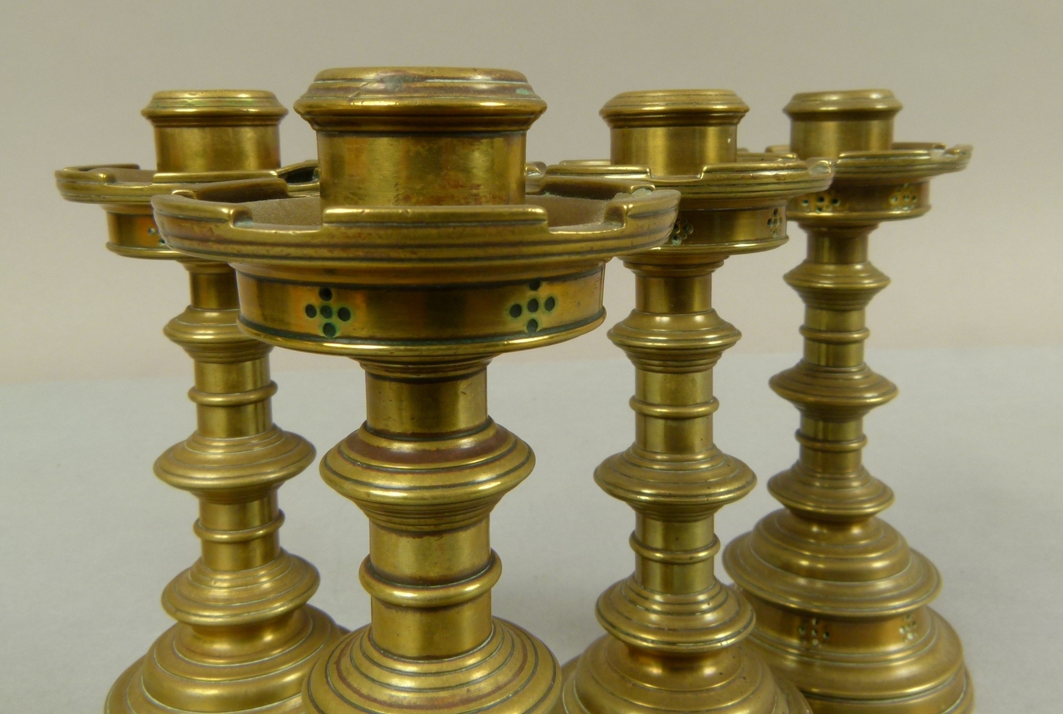 A set of four Victorian brass table candlesticks in the 'Gothic' style, cylindrical nozzles with - Image 3 of 3