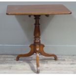 A Victorian oak tilt top table of rectangular outline on a turned column and tripod base