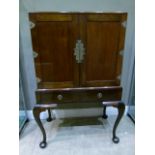 A mahogany drinks cabinet converted to a television cabinet, having two indented doors with brass