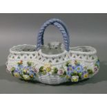 A French floral encrusted basket with arched interlaced blue rope twist handles, the interior