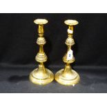 A Pair Of Circular Based Antique Brass Candle Holders With Pusher Bases, 11" High