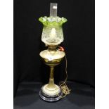 A Circular Based Brass Column Oil Lamp With Green Tinted Shade