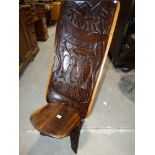 A Carved Ethnic Chair Or "Birthing" Chair The Back Carved With Fisherman & Fish Scene