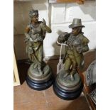 A Pair Of Cold Painted Spelter Figures On Circular Wooden Plinths