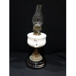 A Circular Based Brass Column Oil Lamp With Milk Glass Reservoir