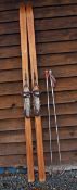 Pair of Vintage Wooden Skis with metal foot brace and leather strap and a pair of Poles with Tiroler