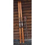 Pair of Vintage Wooden Skis with metal foot brace and leather strap and a pair of Poles with Tiroler