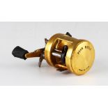 Penn International 955 Baitcast Fishing Reel finished in gold, made in U.S.A, soft grip handles,