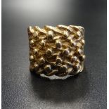 HEAVY NINE CARAT GOLD RING with raised decoration, ring size W-X and approximately 17.2 grams