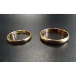 TWO GOLD WEDDING BANDS one in nine carat gold, ring size J-K and approximately 0.8 grams; the